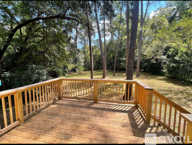 A wooden deck overlooks a grassy area with trees.