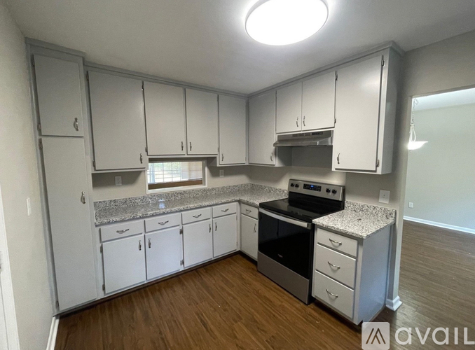 A kitchen with white cabinets and a granite countertop.