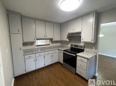 A kitchen with white cabinets and a granite countertop.