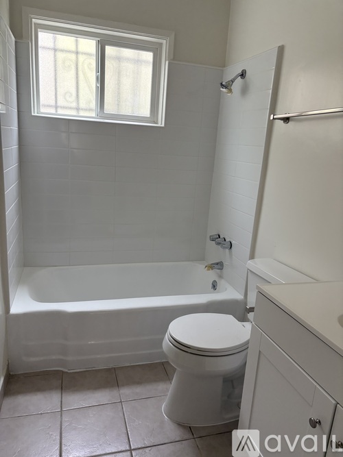 A white toilet sits next to a bathtub in a bathroom.