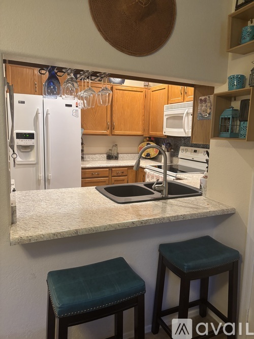 A kitchen with a white fridge and a white counter top.