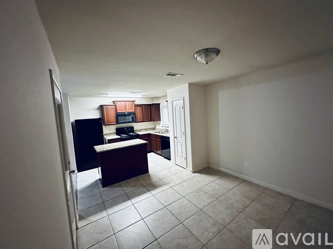 A kitchen area with a refrigerator, microwave, and sink.