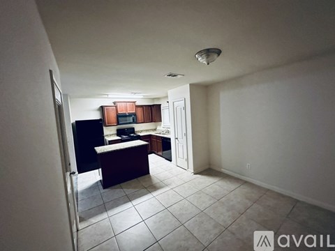 A kitchen area with a refrigerator, microwave, and sink.