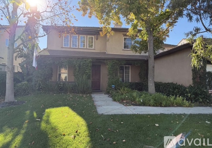A house with a brown facade and a green lawn in front.