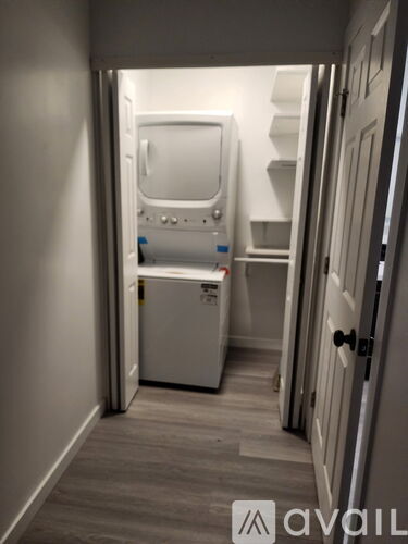 A small white appliance is in a narrow hallway.