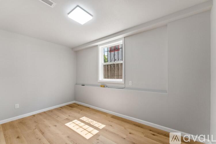 A room with a window and wooden floor.