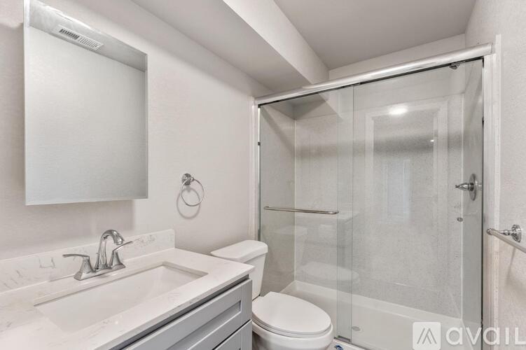 A bathroom with a toilet, sink, and shower.