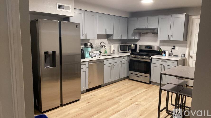A kitchen with a refrigerator, stove, and sink.
