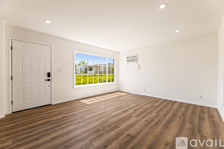 A room with wooden flooring and a white door.