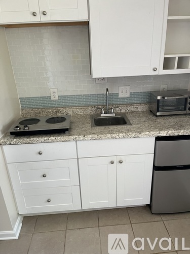 A kitchen with white cabinets and a granite countertop.