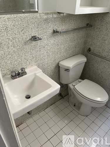 A white toilet sits next to a white sink in a bathroom.