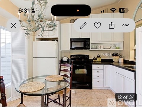 A kitchen with a table and chairs in front of a refrigerator.