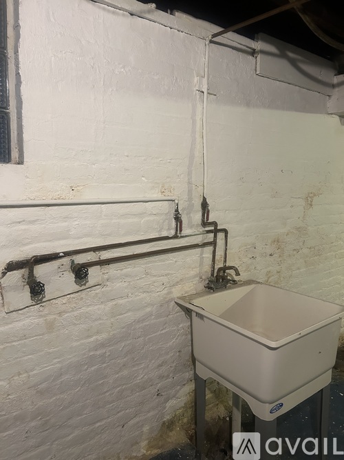 A white sink is installed in a white wall.