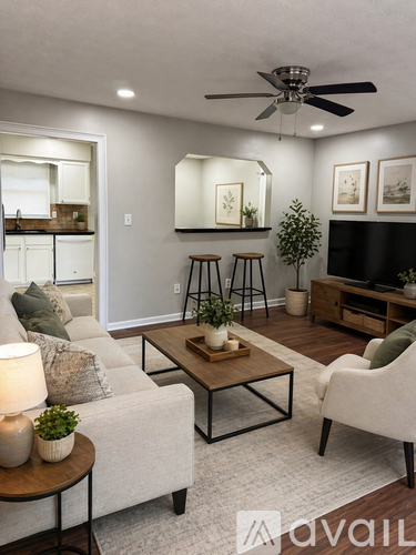 A living room with a white couch, a wooden coffee table, and a ceiling fan.