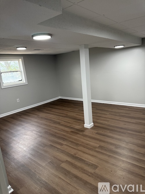 A room with wooden flooring and a window.