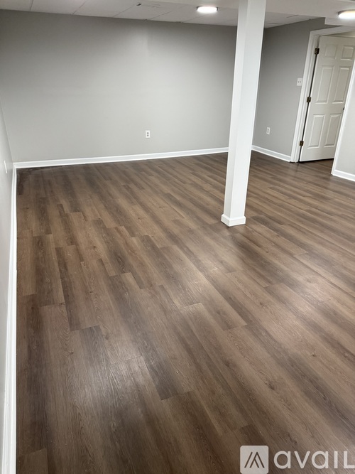 A room with wooden flooring and a white door.