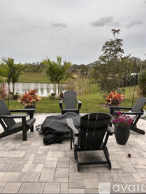 A patio with chairs and a table is set up for an outdoor meal.