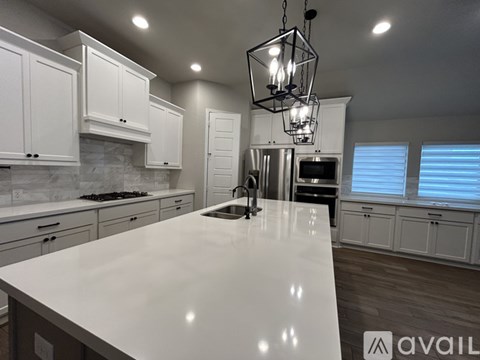 A modern kitchen with white cabinets and a large island.