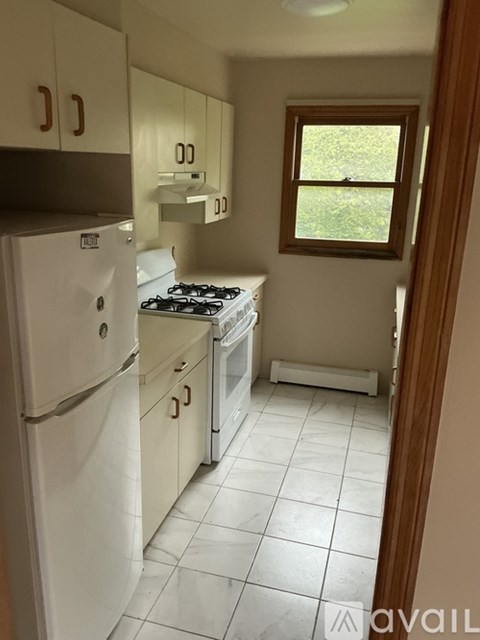 A kitchen with white appliances and cabinets.