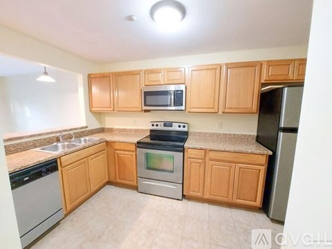 A kitchen with wooden cabinets and stainless steel appliances.