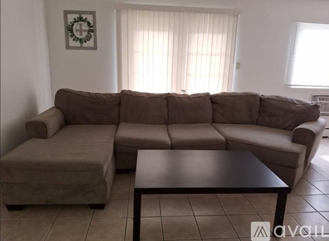 A brown sectional sofa with a coffee table in front of it.