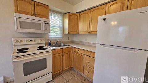 A kitchen with wooden cabinets and white appliances.