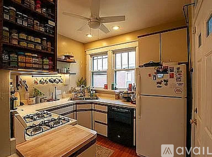 A kitchen with a white fridge and a wooden stove top.