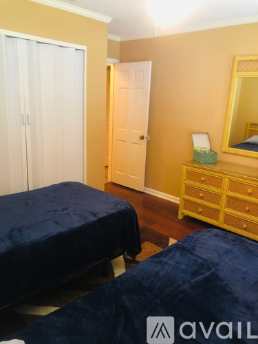 A bedroom with two beds and a yellow dresser.
