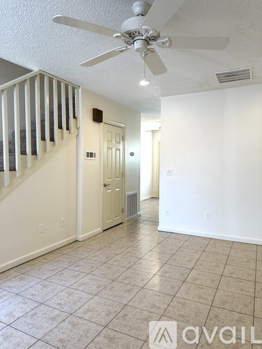 A room with a fan and tiled flooring.