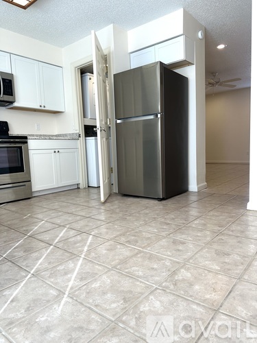 A kitchen with a refrigerator, microwave, and oven.