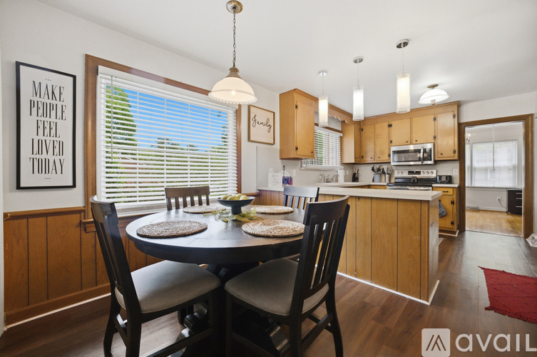 A kitchen with wooden cabinets and a dining table with chairs.