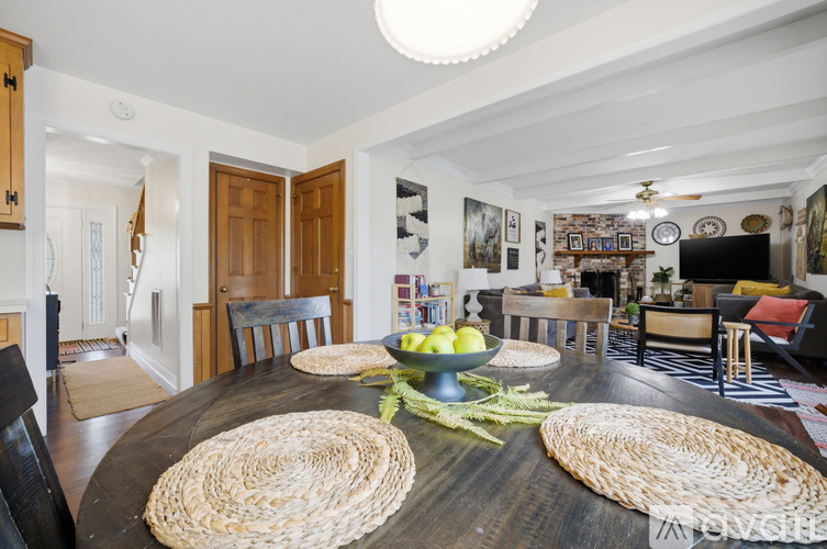 A dining room with a wooden table and woven placemats.