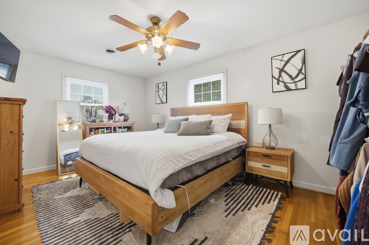 A bedroom with a large bed and a ceiling fan.