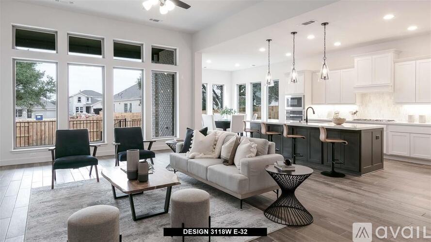A modern living room with a kitchen in the background.