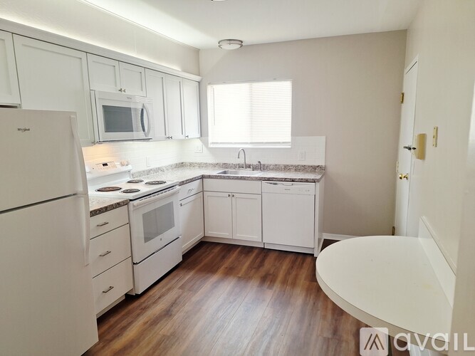 A kitchen with white appliances and cabinets.