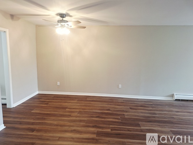 A room with wooden flooring and a ceiling fan.