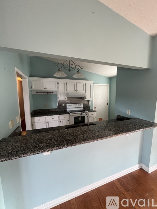 A kitchen with a granite countertop and white cabinets.