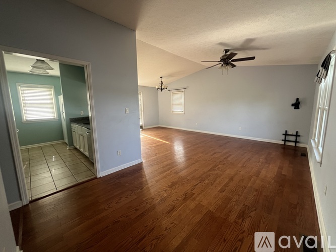 A room with wooden floors and a ceiling fan.