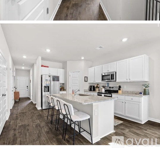 A kitchen with white cabinets and a marble countertop.