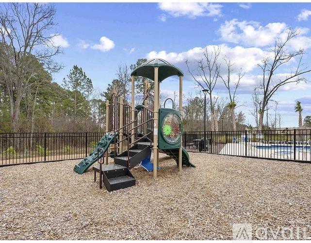 A playground with a green slide and a wooden structure.