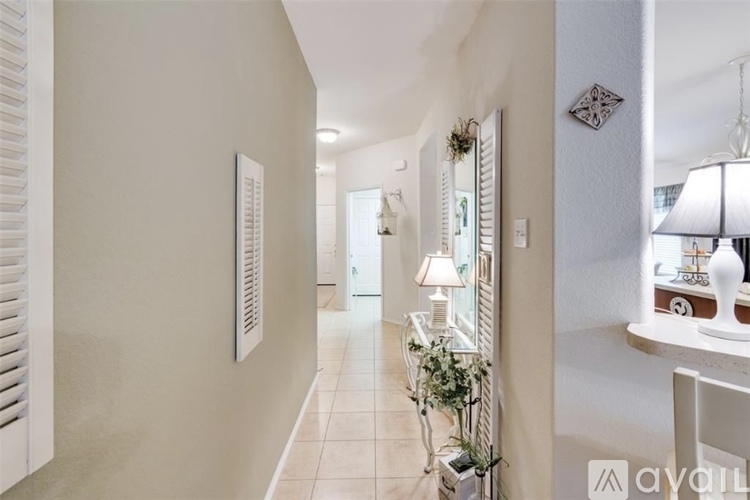 A hallway with a white lamp and a mirror on the wall.