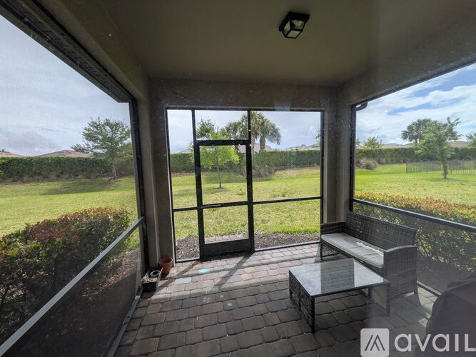 A patio with a glass door leading to a grassy area.