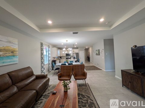 A living room with a brown leather couch and a wooden coffee table.