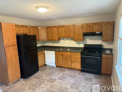 A kitchen with wooden cabinets and black appliances.
