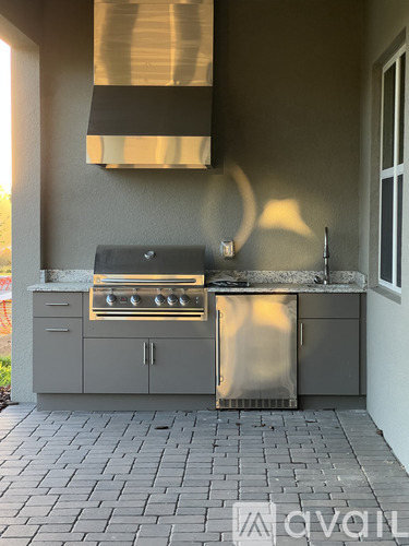 A modern outdoor kitchen with a built-in grill and sink.