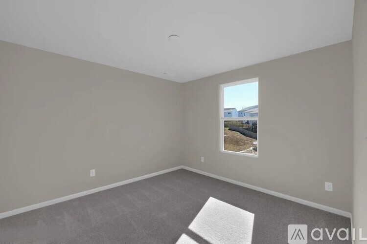 A room with a window showing a view of a building outside.