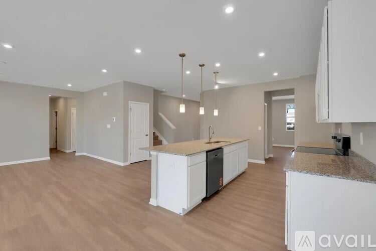 A spacious kitchen with white cabinets and a granite countertop.