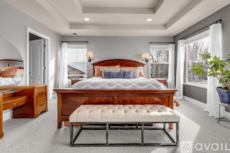 A bedroom with a large bed and a bench in front of it.