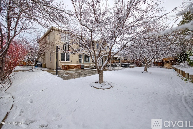 A house with a snow-covered front yard and bare trees.