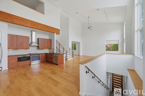 A spacious kitchen with wooden cabinets and a stainless steel oven.